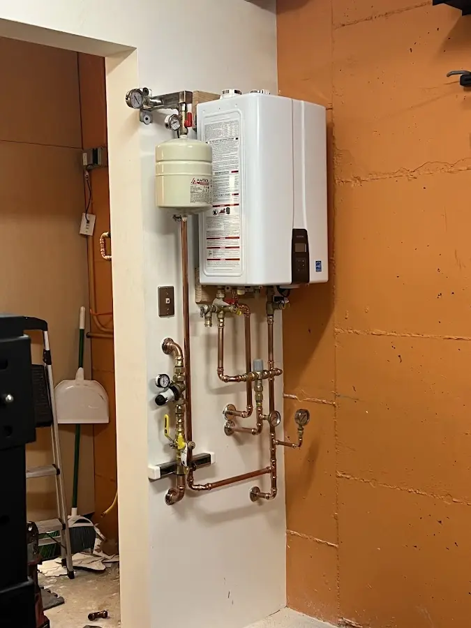 Plumbing technician inspecting water heater connections in Annandale